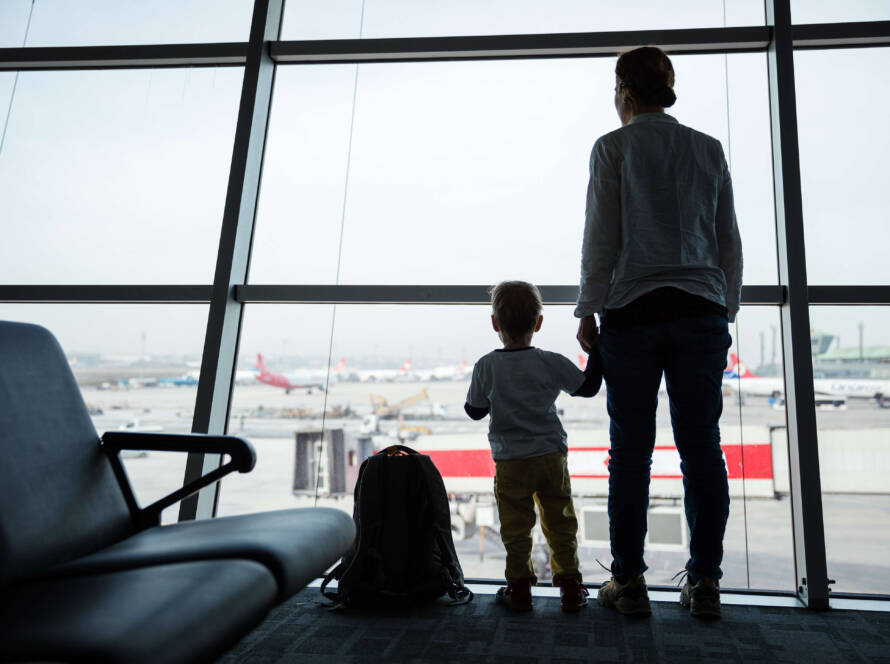 mother-and-son-standing-near-window-in-airport